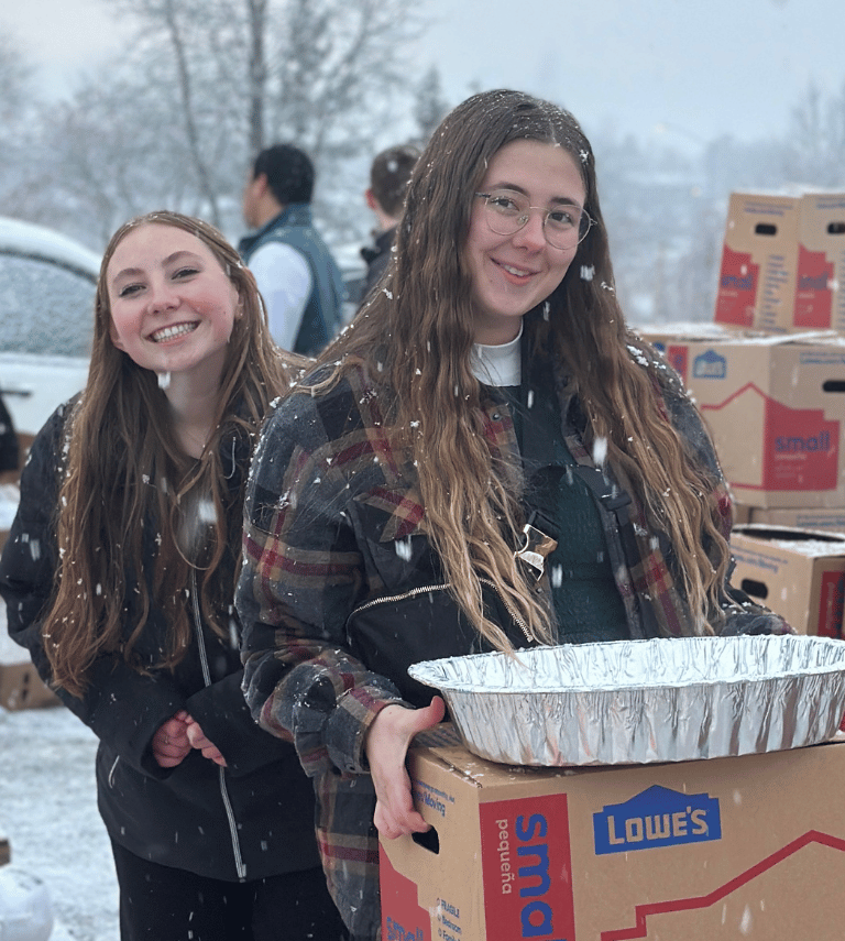 Two girls serving turkeys outside