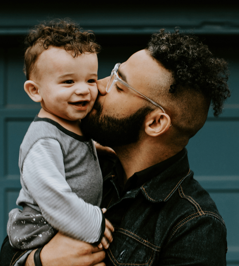 Father holding onto his son and smiling